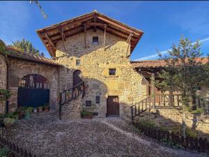 een groot stenen gebouw met een trap ervoor bij LITTLE TOWER in Potes