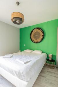 a bedroom with a green wall with a bed at Le petit Taison - Metz Hyper center in Metz