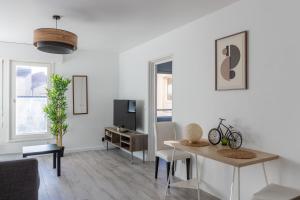 a living room with a table and a tv at Le petit Taison - Metz Hyper center in Metz