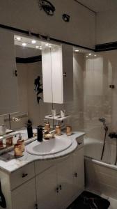 une salle de bain avec un lavabo, une baignoire et un miroir dans l'établissement Ferienperle-Bad-Harzburg-mit-Schwimmbad-und-Sauna, à Bad Harzburg