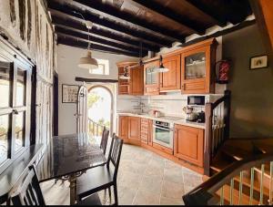 een keuken met houten kasten en een tafel met stoelen bij LITTLE TOWER in Potes