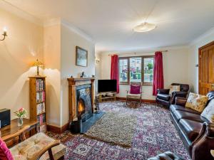a living room with a couch and a fireplace at 3 Bed in Uldale 95374 in Uldale