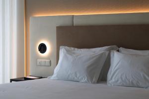 a bedroom with a bed with white pillows at Oporto Fly Hotel in Maia
