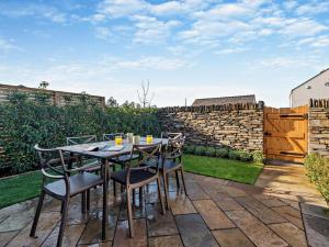 a patio with a table and chairs and a stone wall at 3 Bed in Loweswater 94152 in Arlecdon