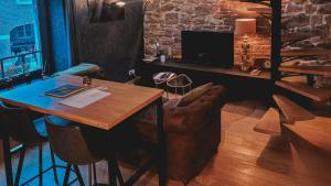 a dining room with a wooden table and a couch at Loft urbain style Brooklyn in Profondeville