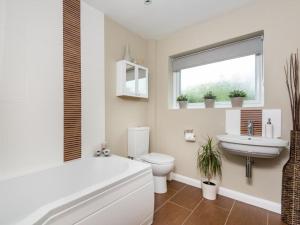 a bathroom with a tub and a toilet and a sink at 4 Bed in Borrowdale SZ219 in Grange