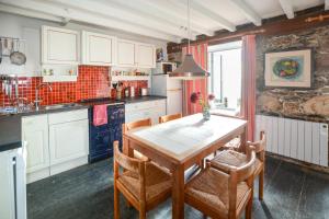 a kitchen with a wooden table and chairs in it at St Michaels in Porthleven