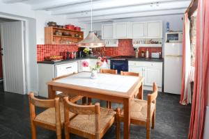 a kitchen with a wooden table with chairs and a table at St Michaels in Porthleven +15 photos