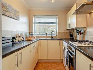 a kitchen with white cabinets and a sink at 2 Bed in Heacham CHLN8 in Heacham