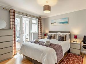 a bedroom with a large bed and a window at 2 Bed in Heacham CHLN8 in Heacham