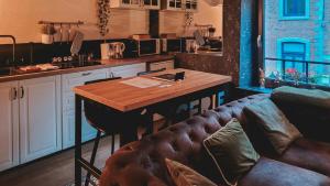 a kitchen with a table and a couch in a room at Loft urbain style Brooklyn in Profondeville