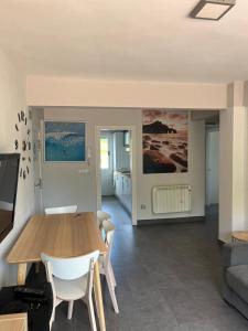 BusturiaにあるAPARTAMENTOS URDAIBAI 4の木製のテーブルと椅子のあるリビングルーム