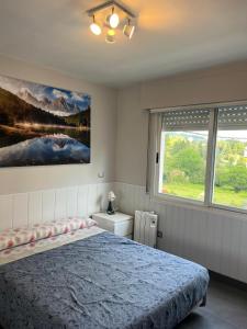 a bedroom with a bed and a painting on the wall at APARTAMENTOS URDAIBAI 4 in Busturia