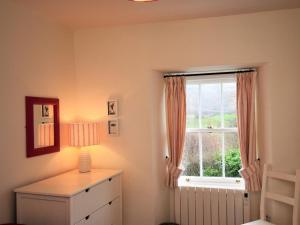 a bedroom with a window and a dresser with a lamp at 3 bed in Eskdale SZ313 in Boot +21 photos