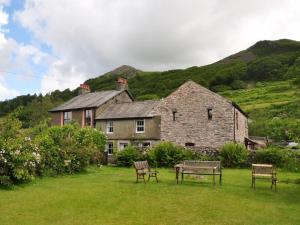 a house with two chairs and a table in a yard at 3 bed in Eskdale SZ313 in Boot