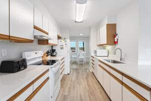 una cocina con armarios blancos y electrodomésticos blancos en CAC-21B - Tuna, en Buxton