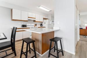 una cocina con armarios blancos y taburetes negros en CAC-21B - Tuna, en Buxton 32 fotos más