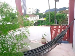 a hammock on a balcony with a potted plant at Muito espaço e natureza no meio da cidade in Santos