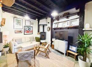 een woonkamer met een bank en een tv bij LITTLE TOWER in Potes