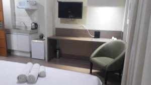 a room with a desk and a chair and a bed at STOP Mar Suite Privada - NI in Nova Iguaçu