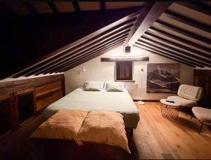 een slaapkamer met een groot bed en een stoel bij LITTLE TOWER in Potes