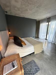 a bedroom with a large bed in a room with windows at Casa Rumenco Joven mdq in Mar del Plata