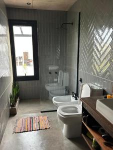 a bathroom with a toilet and a tub and a sink at Casa Rumenco Joven mdq in Mar del Plata
