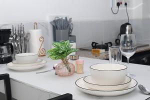 a kitchen counter with plates and wine glasses on it at Makasembo Cozy Serenity in Kisumu +18 photos