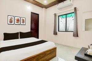 een slaapkamer met een bed en een raam bij HOTEL O SKYLITE Vhirgaon in Pānchgaon +24 foto's