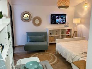 sala de estar con cama y silla en Refúgio junto à falésia, en Olhos de Água