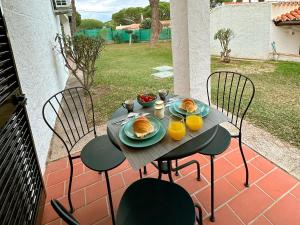 una mesa con platos de comida y naranjas en un patio en Refúgio junto à falésia, en Olhos de Água