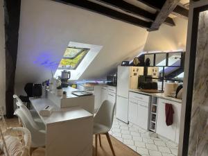 a kitchen with white cabinets and a table and chairs at Appartement dans la Résidence le Chateaux in Fitz-James +16 photos