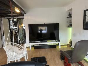 a living room with a large flat screen tv at Appartement dans la Résidence le Chateaux in Fitz-James