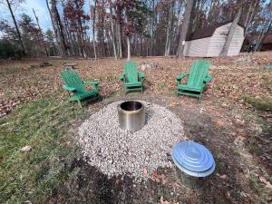 three green chairs and a fire pit in a yard at Large Cabin w Hot Tub, Pond, Deck, Fire Pit, WiFi in Morton Grove +35 photos