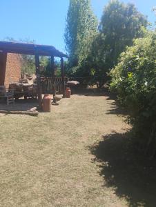 einen Garten mit einem Picknicktisch und einem Pavillon in der Unterkunft Casa de campo con pileta in Alta Gracia