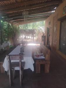 eine Außenterrasse mit einem Tisch und einer Bank in der Unterkunft Casa de campo con pileta in Alta Gracia