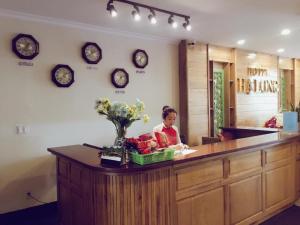 a woman sitting at a counter in a store at Ha Long Hotel Thủ Đức HCMC in Ho Chi Minh City