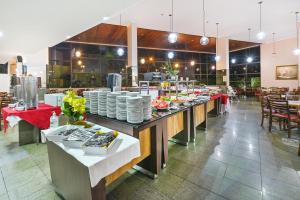 a buffet line with plates and tables in a restaurant at Hotel Nacional Inn Campinas Trevo in Campinas