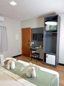 two stuffed animals sitting on a bed in a room at Nature Bonito Hotel in Bonito