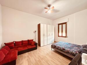 a bedroom with a red couch and a bed at Be Your Home - Casa Vacanze Il Posticino in Civitavecchia
