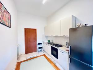 a kitchen with a refrigerator and white cabinets at Be Your Home - Casa Vacanze Il Posticino in Civitavecchia