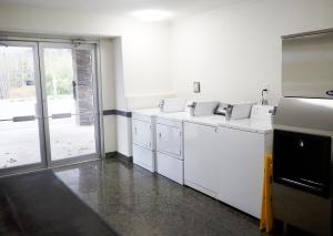 een keuken met witte apparatuur en een groot raam bij Days Inn by Wyndham Valemount in Valemount