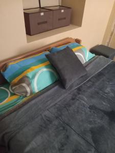 a bed with a black comforter and pillows at Small House Pisac in Pisac