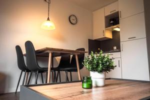 a kitchen with a table and chairs and a clock on the wall at Deichkoje 2 Dagebüll in Dagebüll