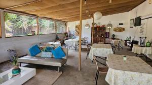 a restaurant with tables and chairs and a couch at Hotel Del Valle Quilimari in Pichidangui