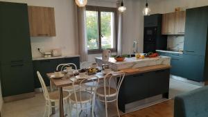 eine Küche mit grünen Schränken und einem Tisch mit Stühlen in der Unterkunft Domaine de la Boria in Montignac