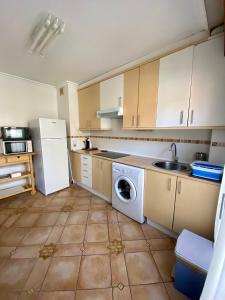 een keuken met een witte koelkast en een wasmachine bij APARTAMENTOS URDAIBAI 7 in Bermeo
