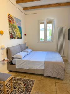 Un dormitorio con una cama y un sofá y una ventana. en Suite Battisti 7, en Lecce