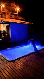 ein blauer Pool an der Seite eines Hauses bei Nacht in der Unterkunft Pousada Caminho do Lago in Rio Rufino + 59 Fotos