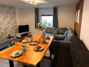 ein Wohnzimmer mit Tisch und Couch in der Unterkunft Nahe Kiel, 4 Betten, 2 Schlafzimmer Parkplatz, Terrasse, 3km zum Strand in Osdorf